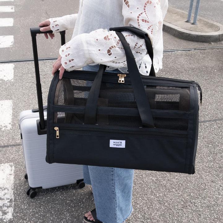 Sac de transport noir en toile et maille, style artisanal, pour animaux, porté à l’aéroport