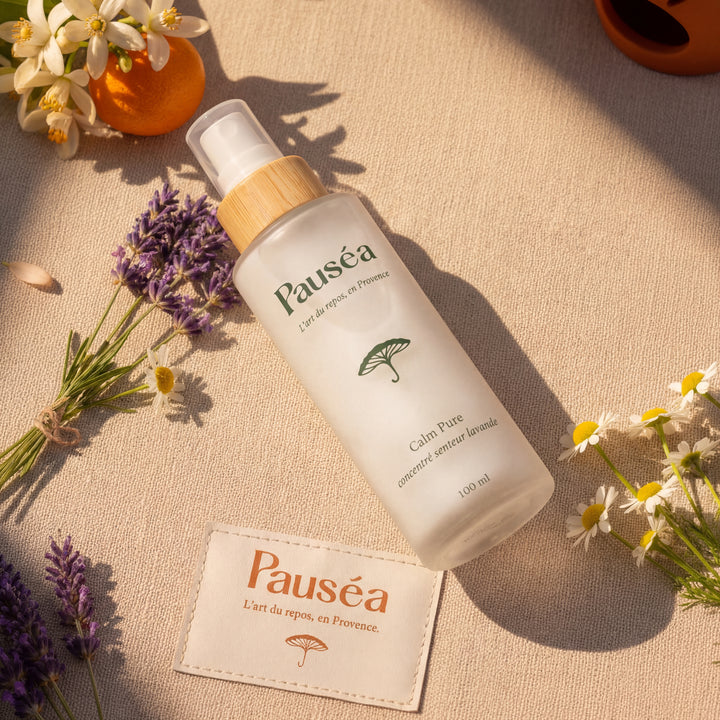 Composition élégante avec le vaporisateur Calm Pure, une carte de la marque et des fleurs séchées, soulignant le caractère fait main et artisanal du soin.