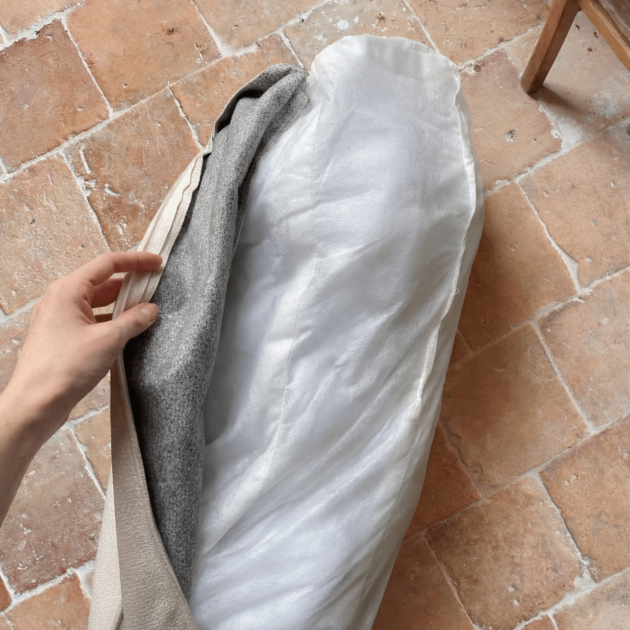 présentation à la main de la partie déhoussable du lit nesto pour chien, et du rembourrage, facile à nettoyer