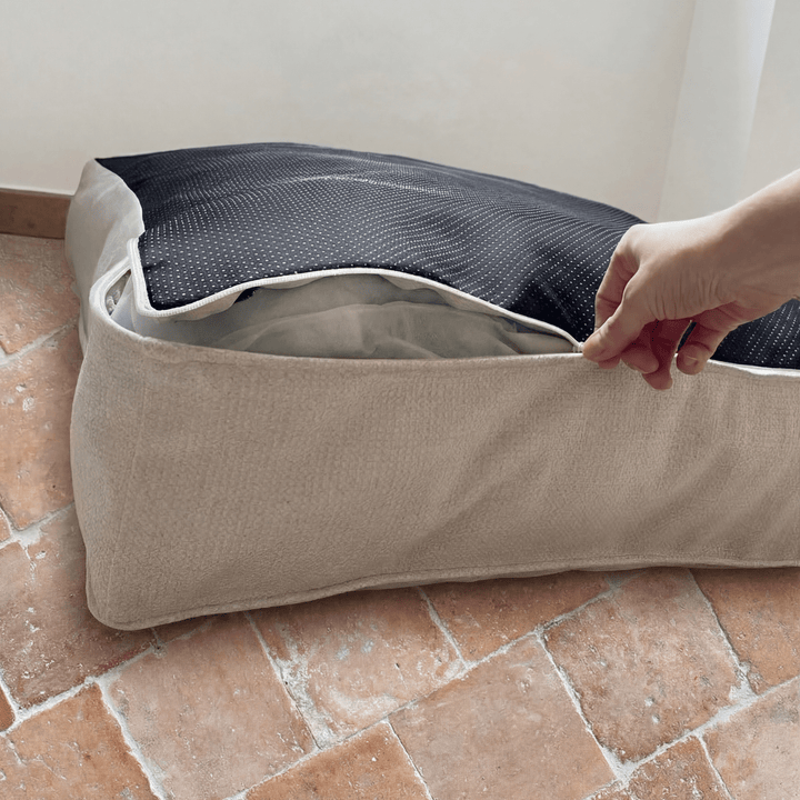 détails couture du panier lit nesto, avec une main qui ouvre la fermeture éclair du panier déhoussable